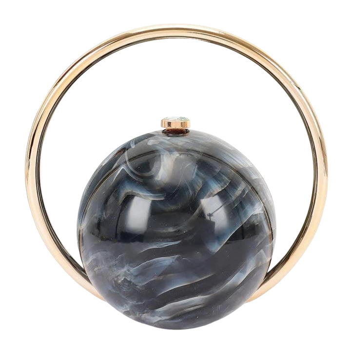 A round evening clutch bag featuring a glossy dark gray and white marbled resin sphere with a small rose gold top button, encircled by a polished gold-tone metal ring on a white background.